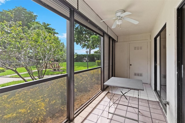 unfurnished sunroom with ceiling fan