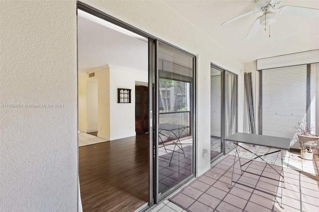 unfurnished sunroom featuring ceiling fan