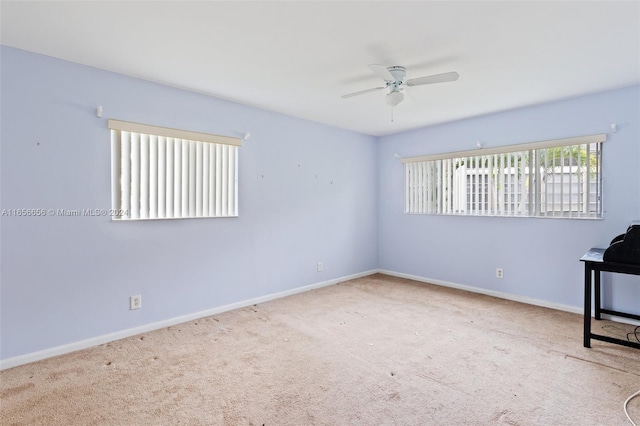 carpeted spare room with ceiling fan