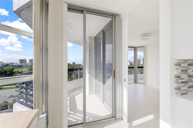 doorway to outside featuring floor to ceiling windows and a city view
