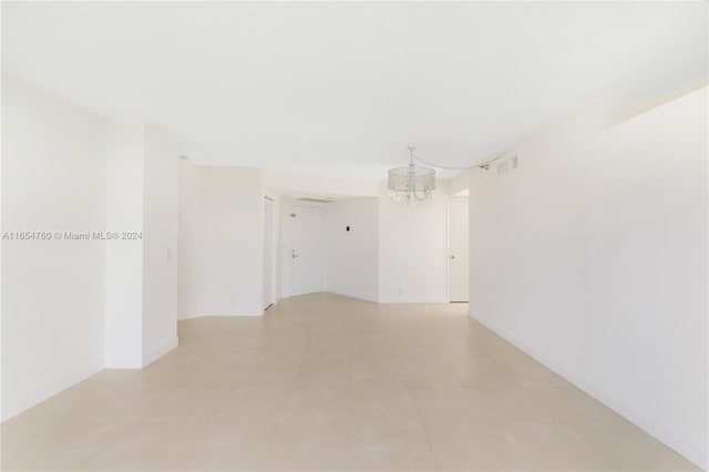 spare room with visible vents, a notable chandelier, and light tile patterned flooring