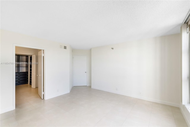 empty room featuring visible vents and a textured ceiling