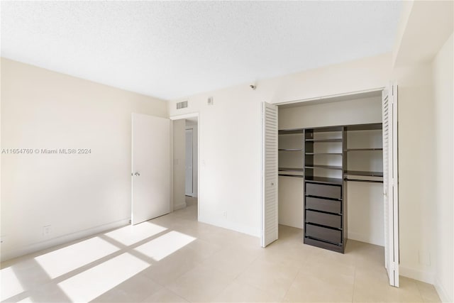 unfurnished bedroom with a closet, visible vents, and a textured ceiling