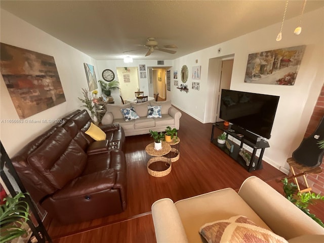 living room featuring dark wood-type flooring and ceiling fan