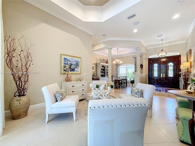 tiled living room featuring ornamental molding, a chandelier, and ornate columns