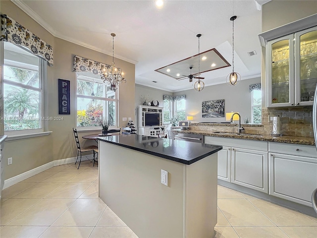 kitchen with tasteful backsplash, sink, light tile patterned flooring, white cabinets, and a chandelier