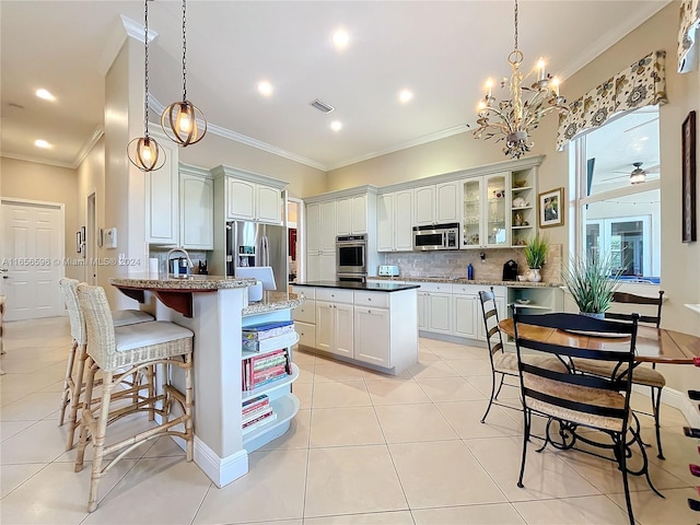 kitchen with crown molding, stainless steel appliances, decorative light fixtures, and white cabinets