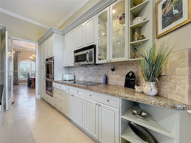 kitchen with stainless steel appliances, a notable chandelier, light tile patterned floors, white cabinets, and light stone counters