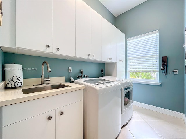 laundry room featuring cabinets, sink, washer and clothes dryer, and light tile patterned floors