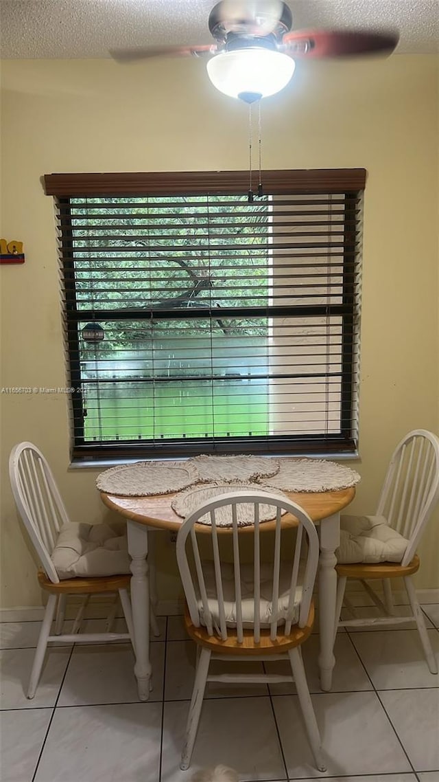 unfurnished dining area featuring a textured ceiling and tile patterned flooring