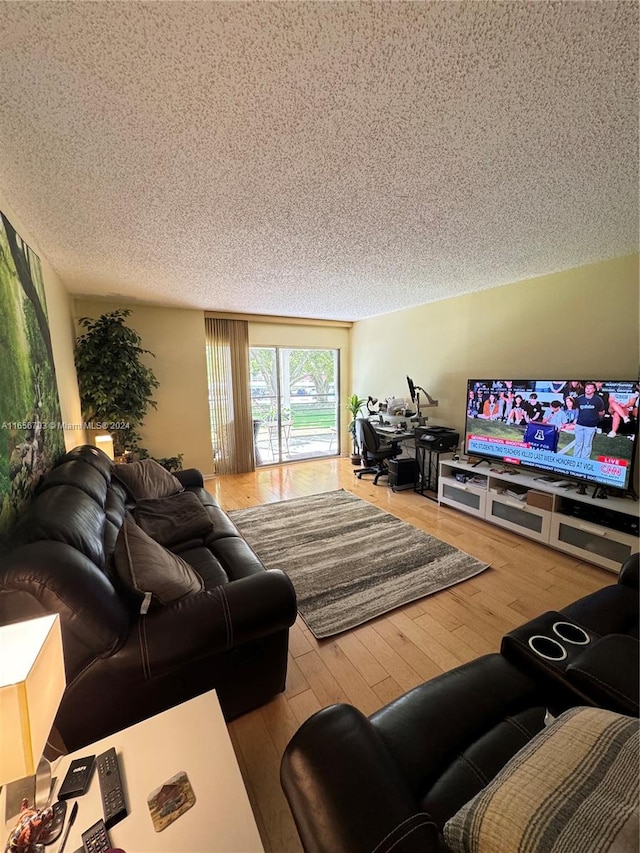 living room featuring a textured ceiling and light wood-type flooring