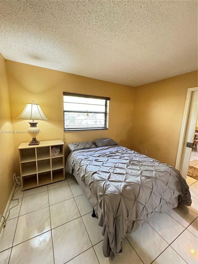 bedroom featuring tile patterned floors and a textured ceiling