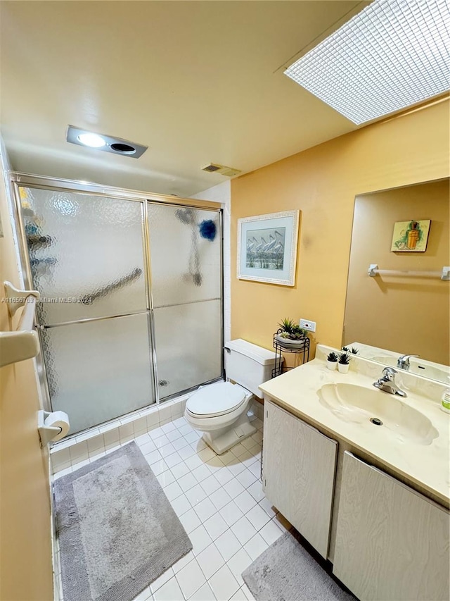 bathroom with a shower with shower door, tile patterned flooring, toilet, and vanity