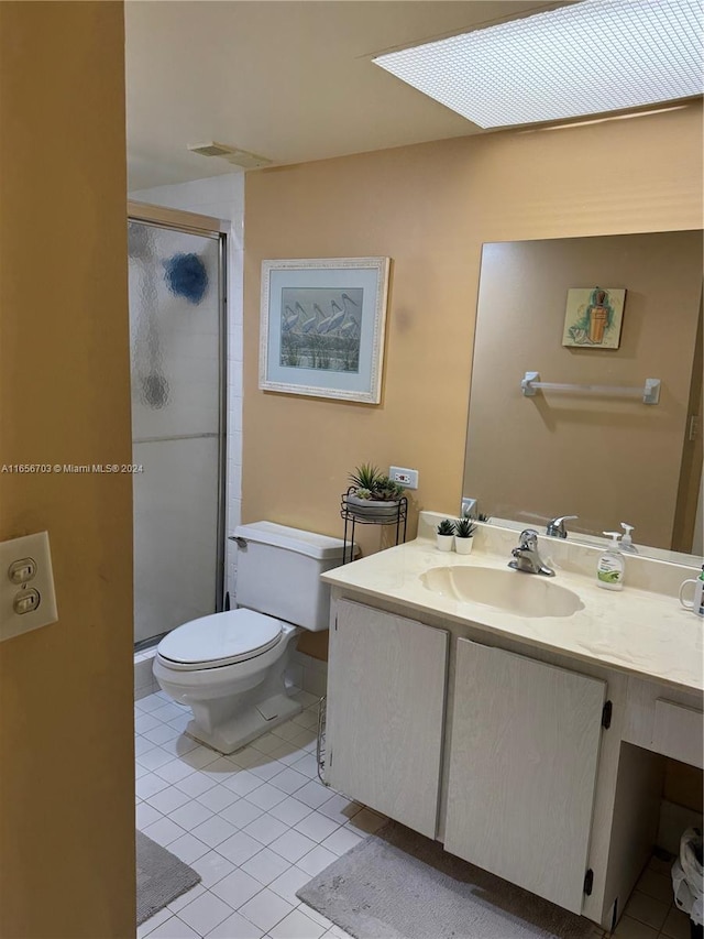 bathroom featuring vanity, toilet, an enclosed shower, and tile patterned floors