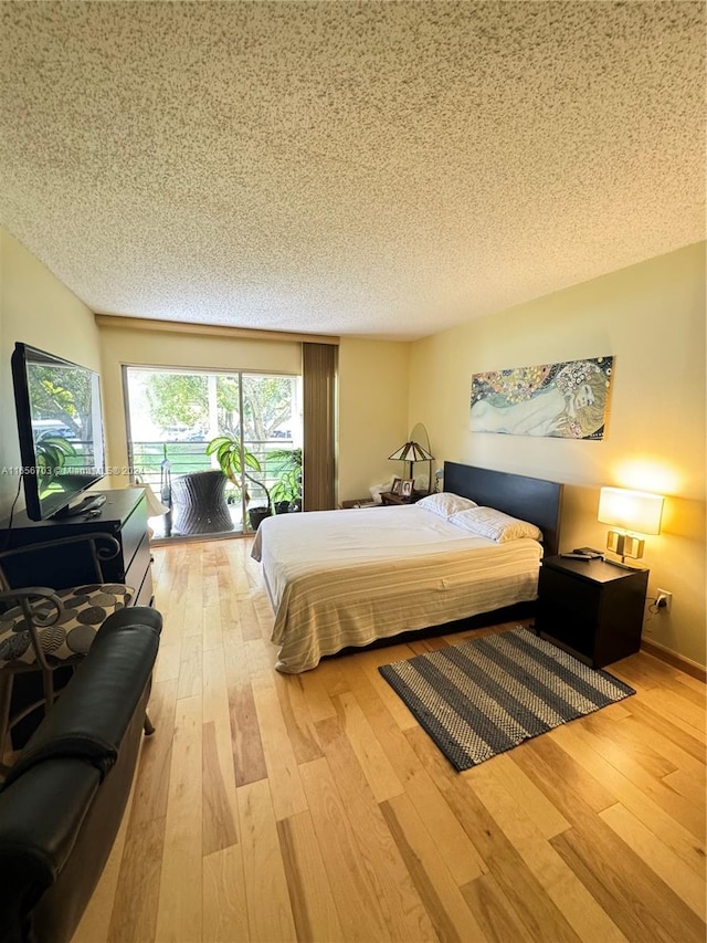 bedroom featuring a textured ceiling and light hardwood / wood-style floors