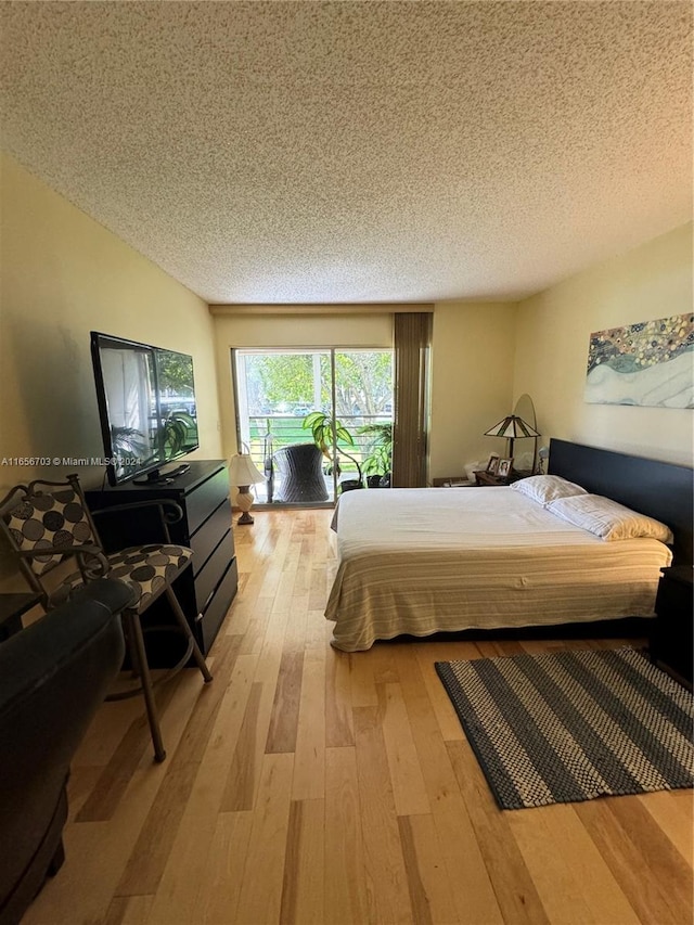 bedroom featuring a textured ceiling and light hardwood / wood-style floors