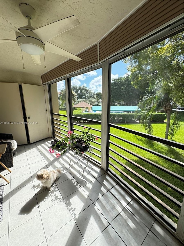 unfurnished sunroom featuring a wealth of natural light and ceiling fan