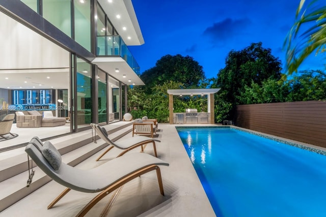 view of swimming pool with fence, a grill, exterior kitchen, a fenced in pool, and a patio area