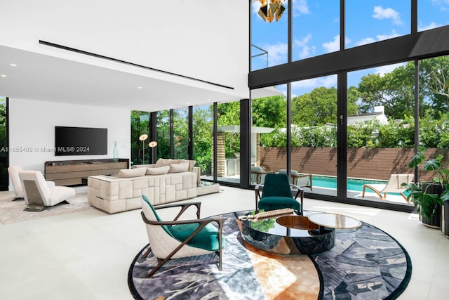 living room featuring a high ceiling and a wall of windows