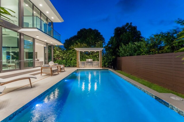 pool at twilight featuring a patio