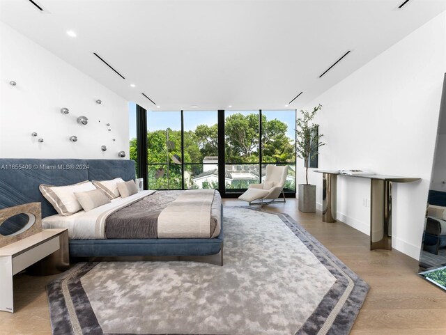 bedroom with hardwood / wood-style flooring and floor to ceiling windows