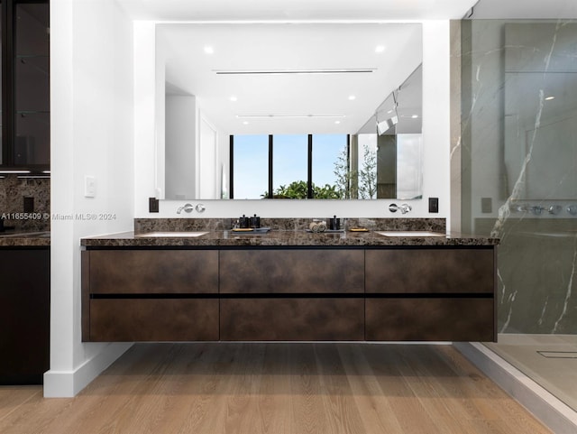 bathroom featuring walk in shower, hardwood / wood-style flooring, decorative backsplash, and vanity