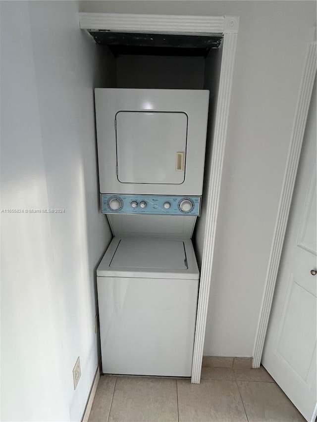 laundry area featuring light tile patterned floors and stacked washer and dryer