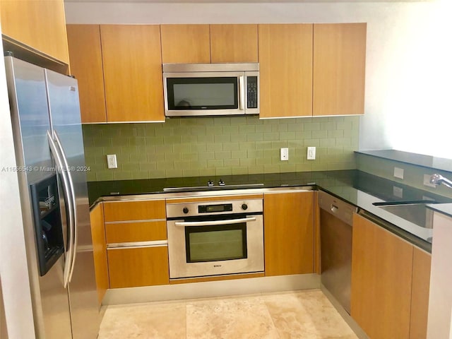 kitchen featuring appliances with stainless steel finishes, tasteful backsplash, and sink