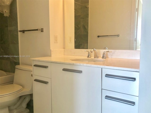 bathroom with toilet, a tile shower, and vanity