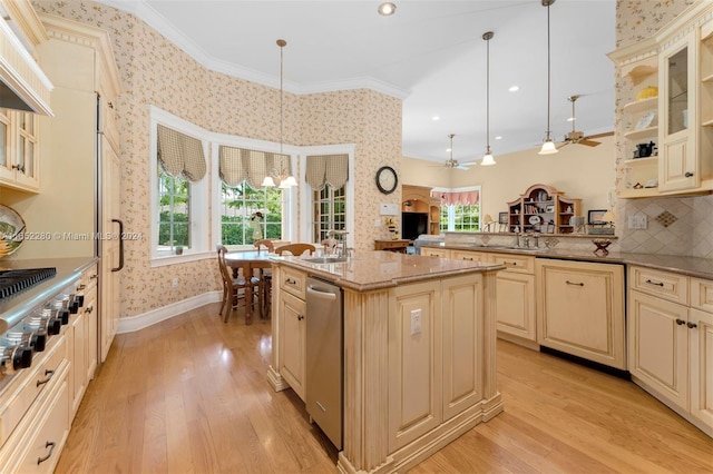 kitchen featuring a healthy amount of sunlight, light hardwood / wood-style floors, crown molding, and decorative light fixtures