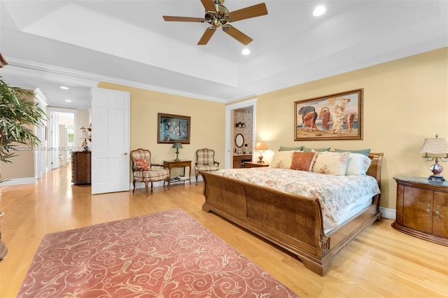 bedroom with crown molding, ceiling fan, light hardwood / wood-style flooring, and a raised ceiling