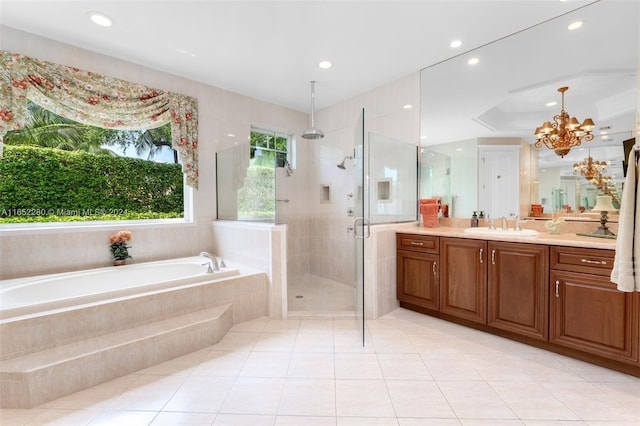 bathroom with a notable chandelier, vanity, tile patterned flooring, and separate shower and tub