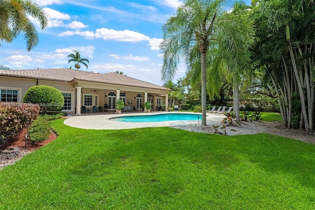 view of pool featuring ceiling fan, a patio area, and a yard