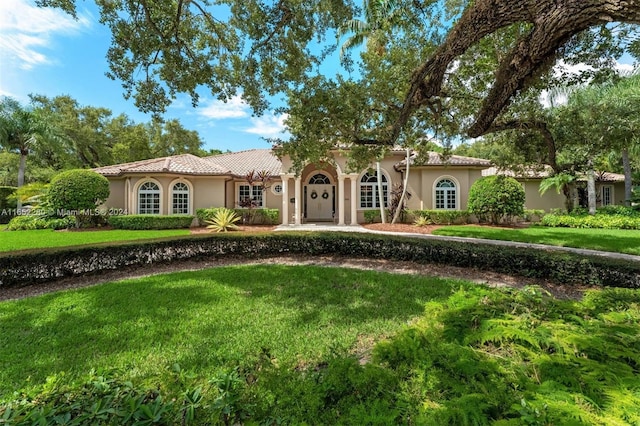 mediterranean / spanish house with a front lawn