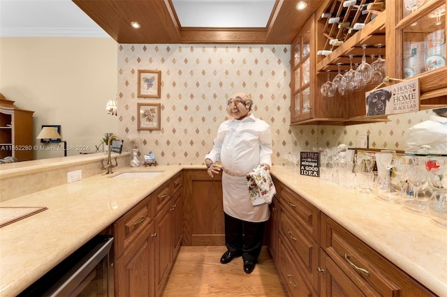 kitchen featuring wine cooler, light hardwood / wood-style flooring, crown molding, and sink