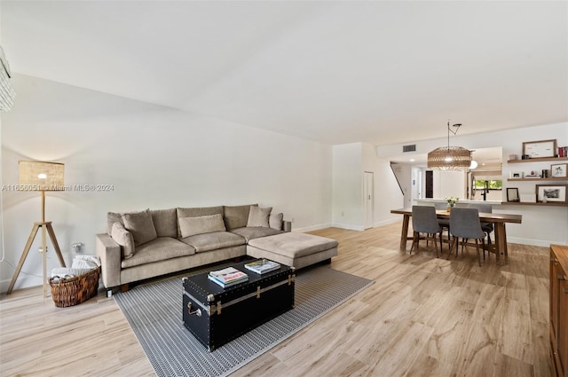 living room featuring an inviting chandelier and light hardwood / wood-style floors