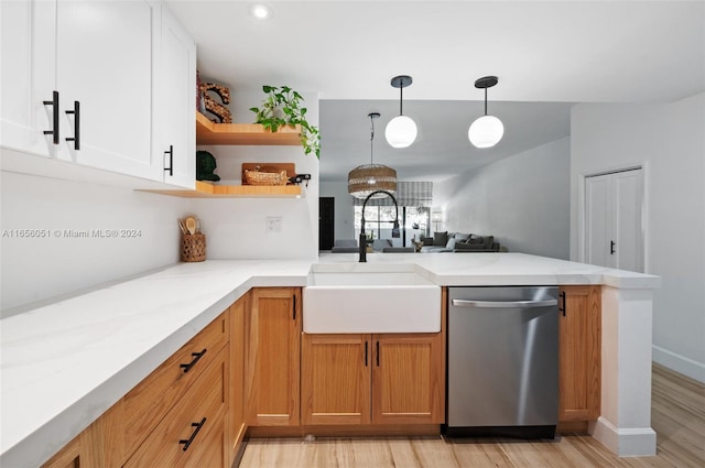 kitchen with kitchen peninsula, stainless steel dishwasher, light hardwood / wood-style flooring, white cabinetry, and light stone countertops