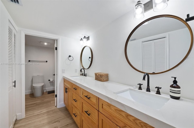 bathroom featuring hardwood / wood-style floors, vanity, and toilet