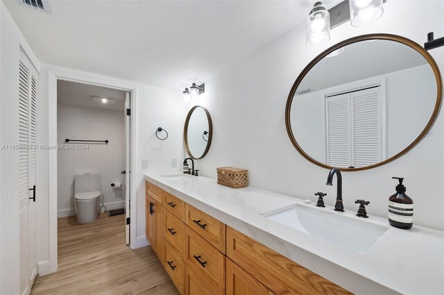 2600 Cardena St Unit 11, Coral Gables, FL 33134 - bathroom with a closet, double vanity, wood finished floors, and toilet
