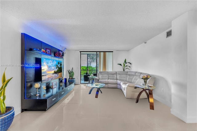 living room with a textured ceiling and tile patterned floors