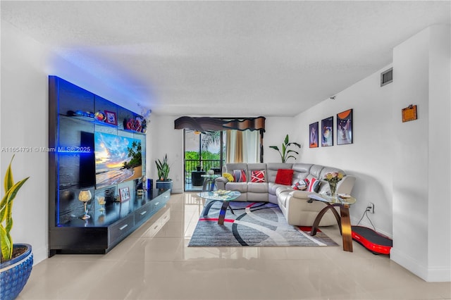 900 NE 195th St Unit 317, Miami, FL 33179 - living area with a textured ceiling, tile patterned flooring, and baseboards