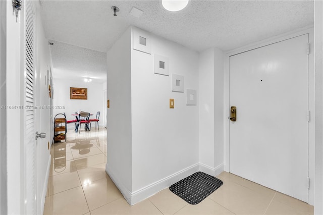 foyer featuring light tile patterned floors and a textured ceiling