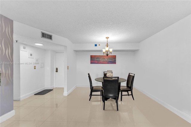 dining room featuring a chandelier, a textured ceiling, and light tile patterned floors