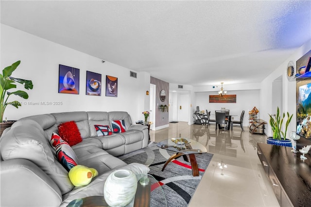 900 NE 195th St Unit 317, Miami, FL 33179 - living room with a textured ceiling, light tile patterned floors, and a chandelier