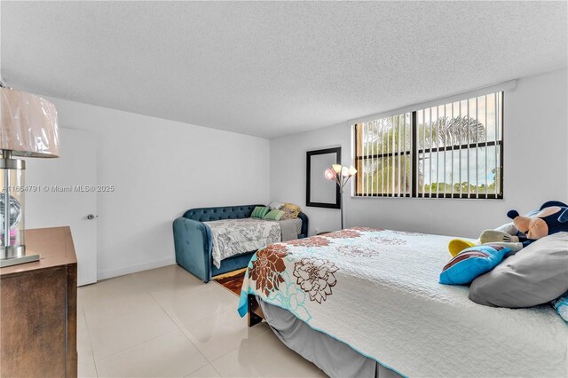 bedroom featuring light tile patterned floors and a textured ceiling