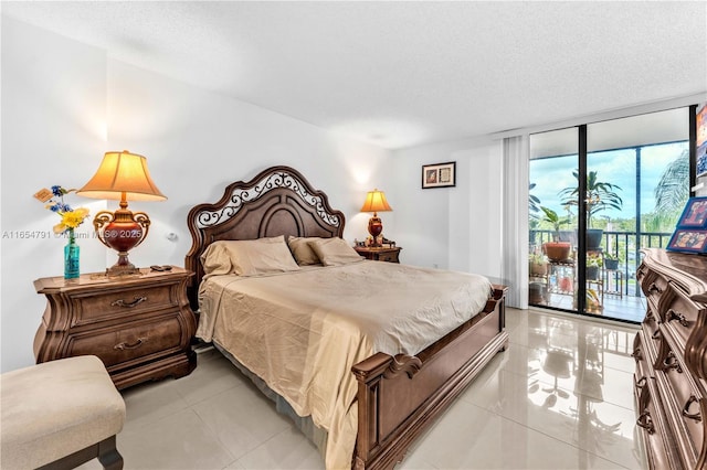 900 NE 195th St Unit 317, Miami, FL 33179 - bedroom with access to exterior, light tile patterned floors, a wall of windows, and a textured ceiling