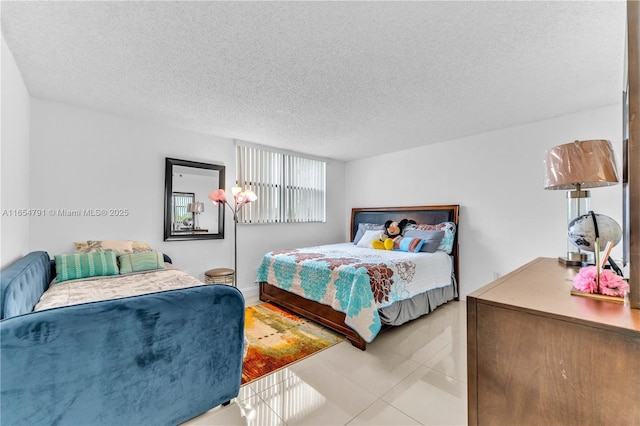 900 NE 195th St Unit 317, Miami, FL 33179 - bedroom with a textured ceiling and tile patterned floors