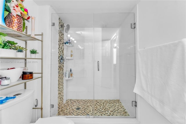 bathroom with a shower with door and toilet