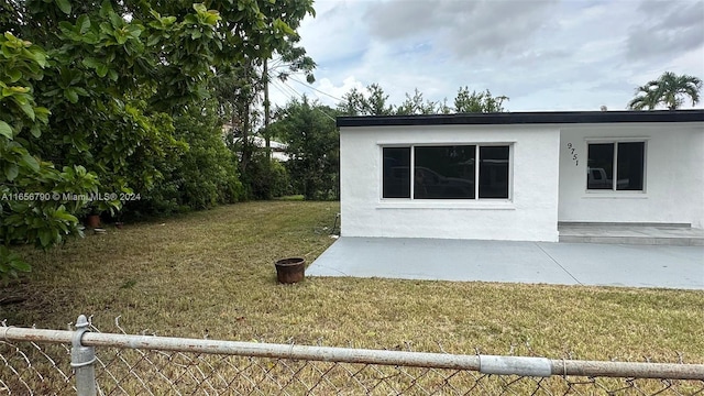 view of side of home with a lawn and a patio area