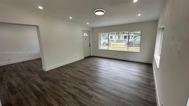 unfurnished room with dark hardwood / wood-style flooring